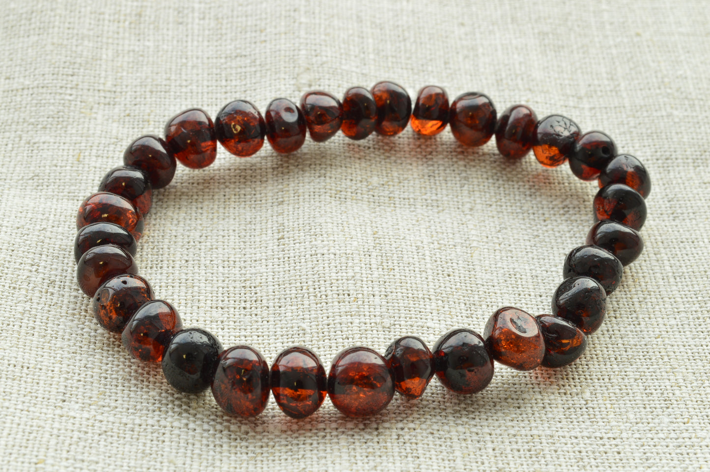 Beaded amber bracelet on a textured fabric background