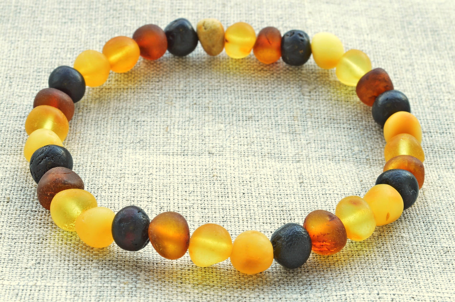 Multicolored beaded bracelet on a textured fabric background