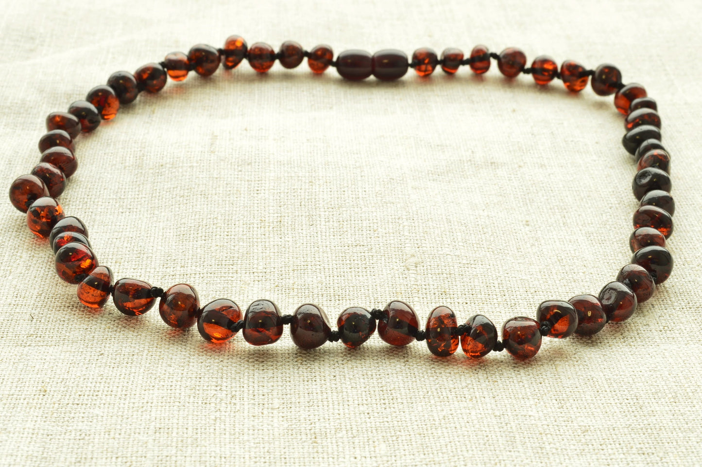 Necklace with amber beads on a light fabric background