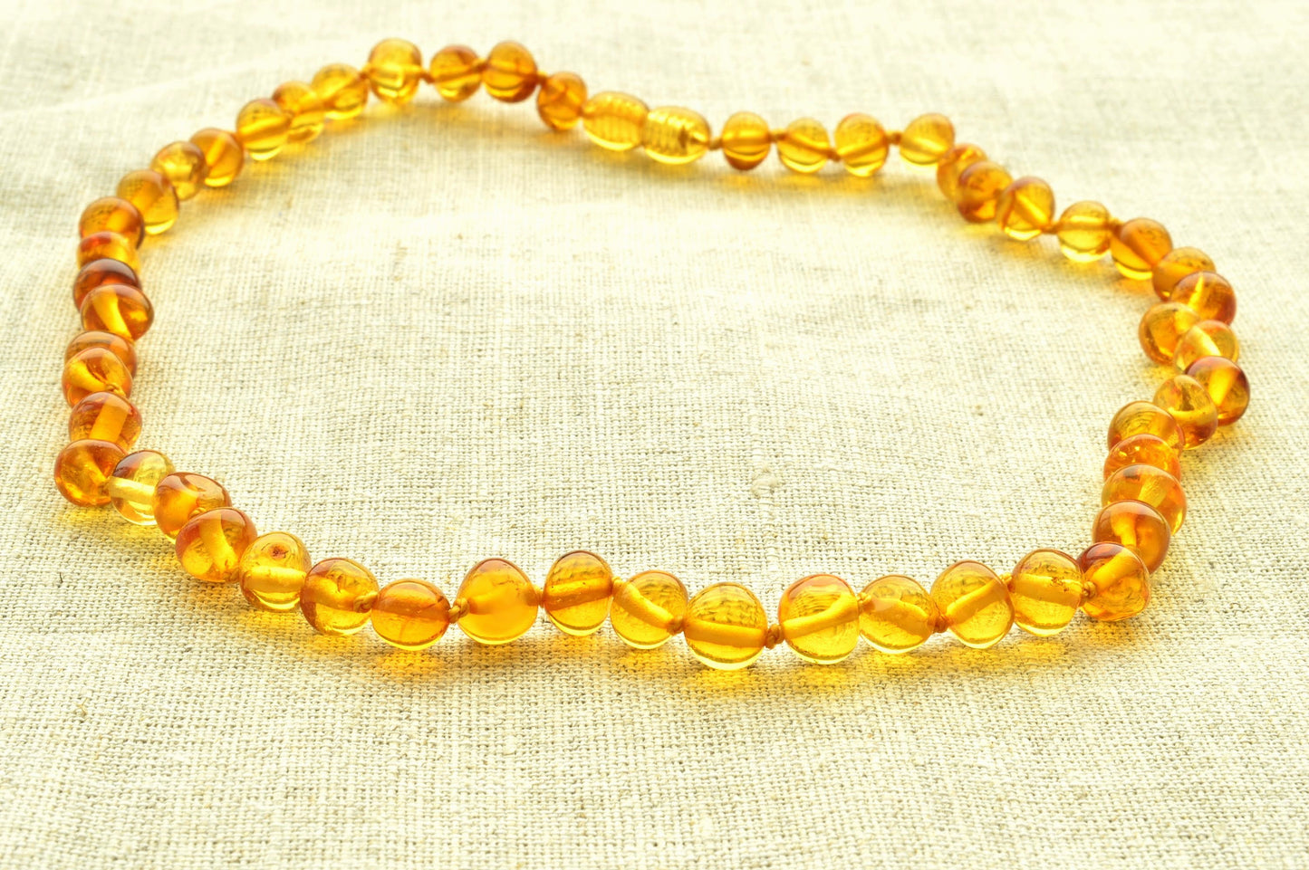 Yellow beaded necklace on a textured beige background