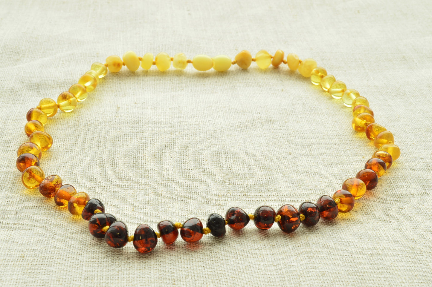Necklace with multicolored beads on a textured beige background