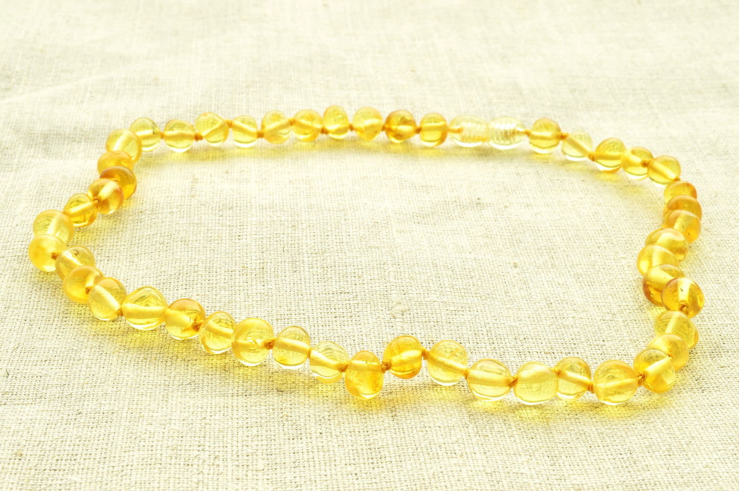 Yellow beaded bracelet on a beige fabric background