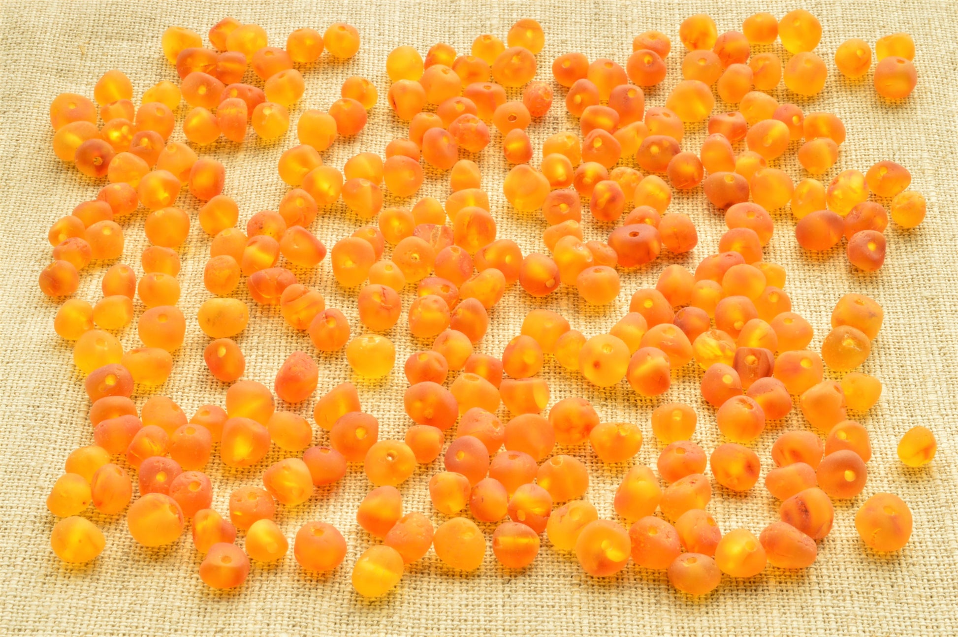 Orange berries scattered on a textured beige surface