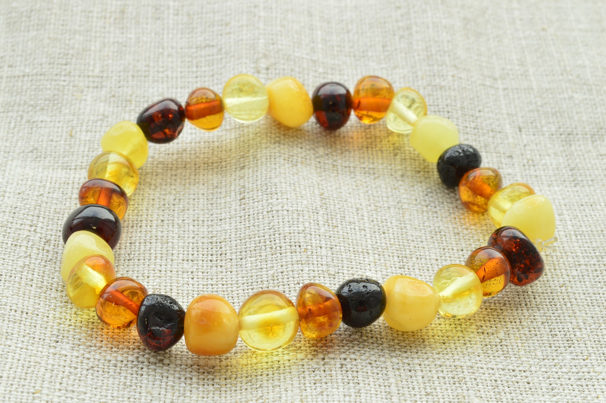 Multicolored beaded bracelet on a textured fabric background