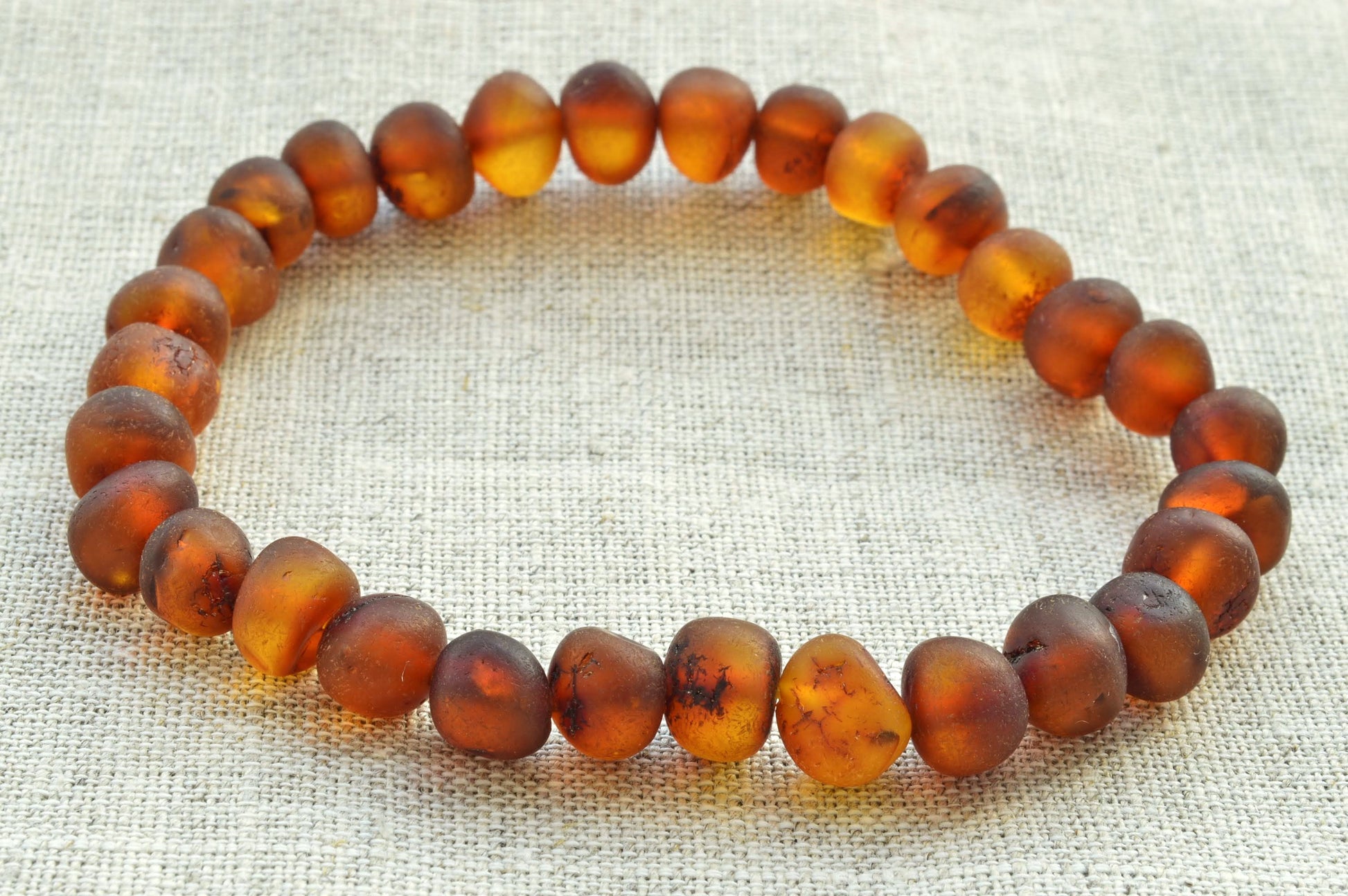 Amber beaded bracelet on a textured fabric background