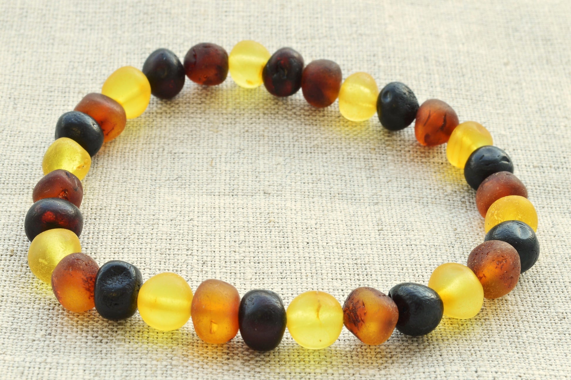 Multicolored beaded bracelet on a textured fabric background