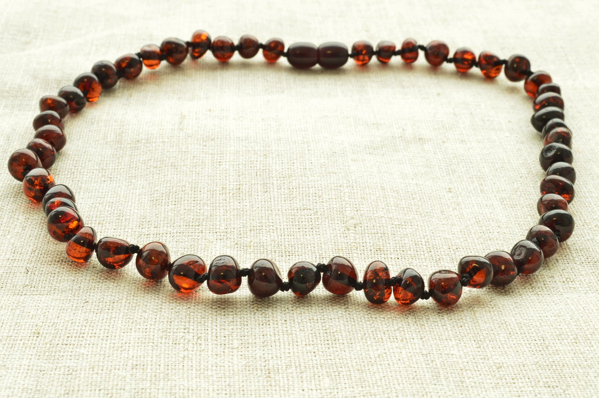 Necklace with amber beads on a light fabric background