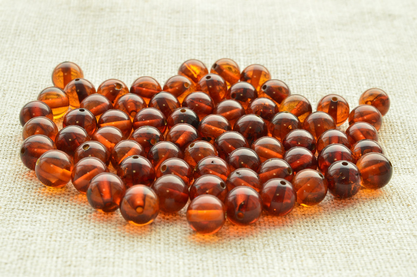 Natural baltic amber Brown beads on a textured beige fabric background