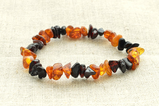 Bracelet made of brown and black  amber on a textured beige background