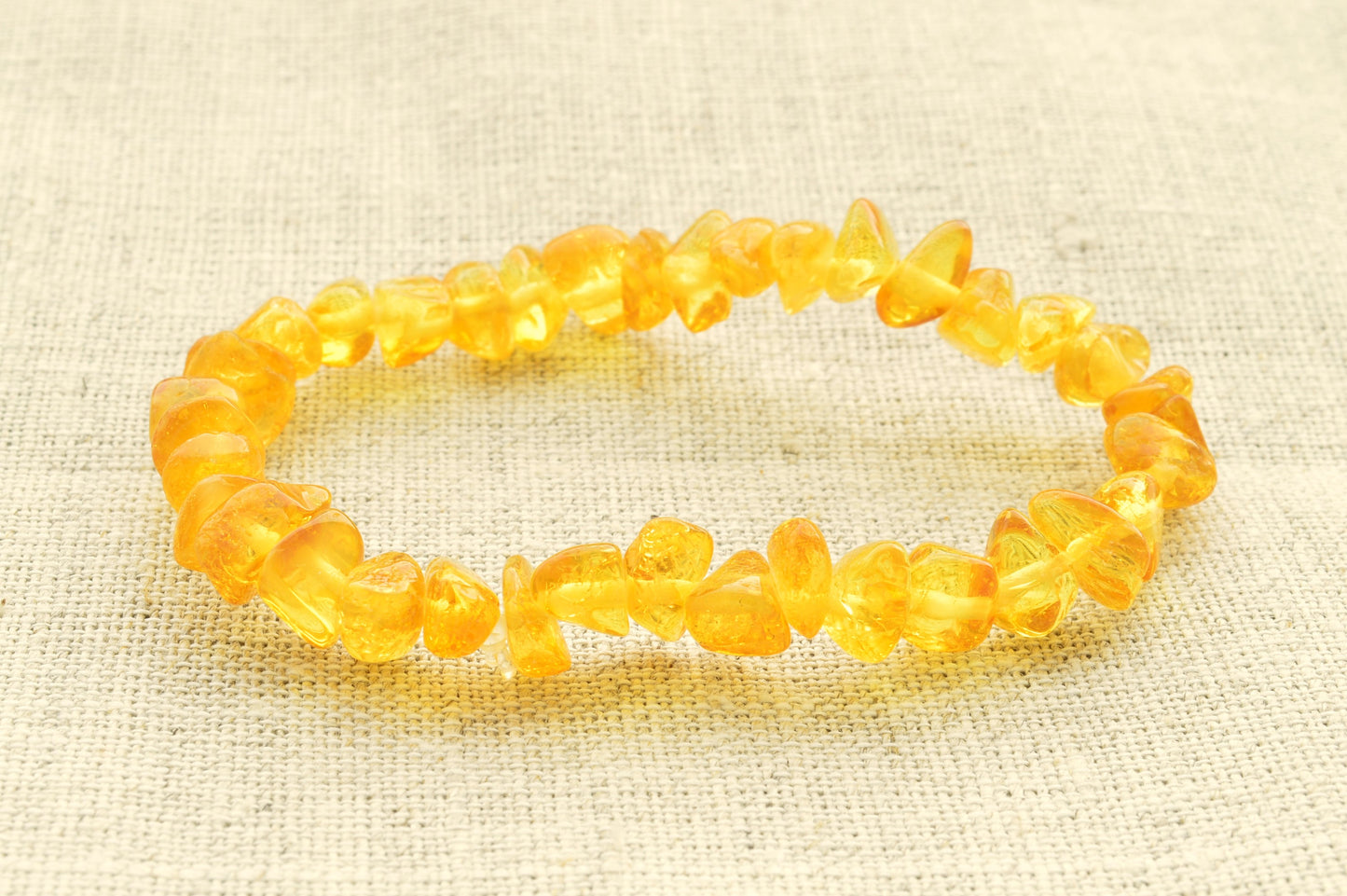 Yellow beaded bracelet on a textured beige background