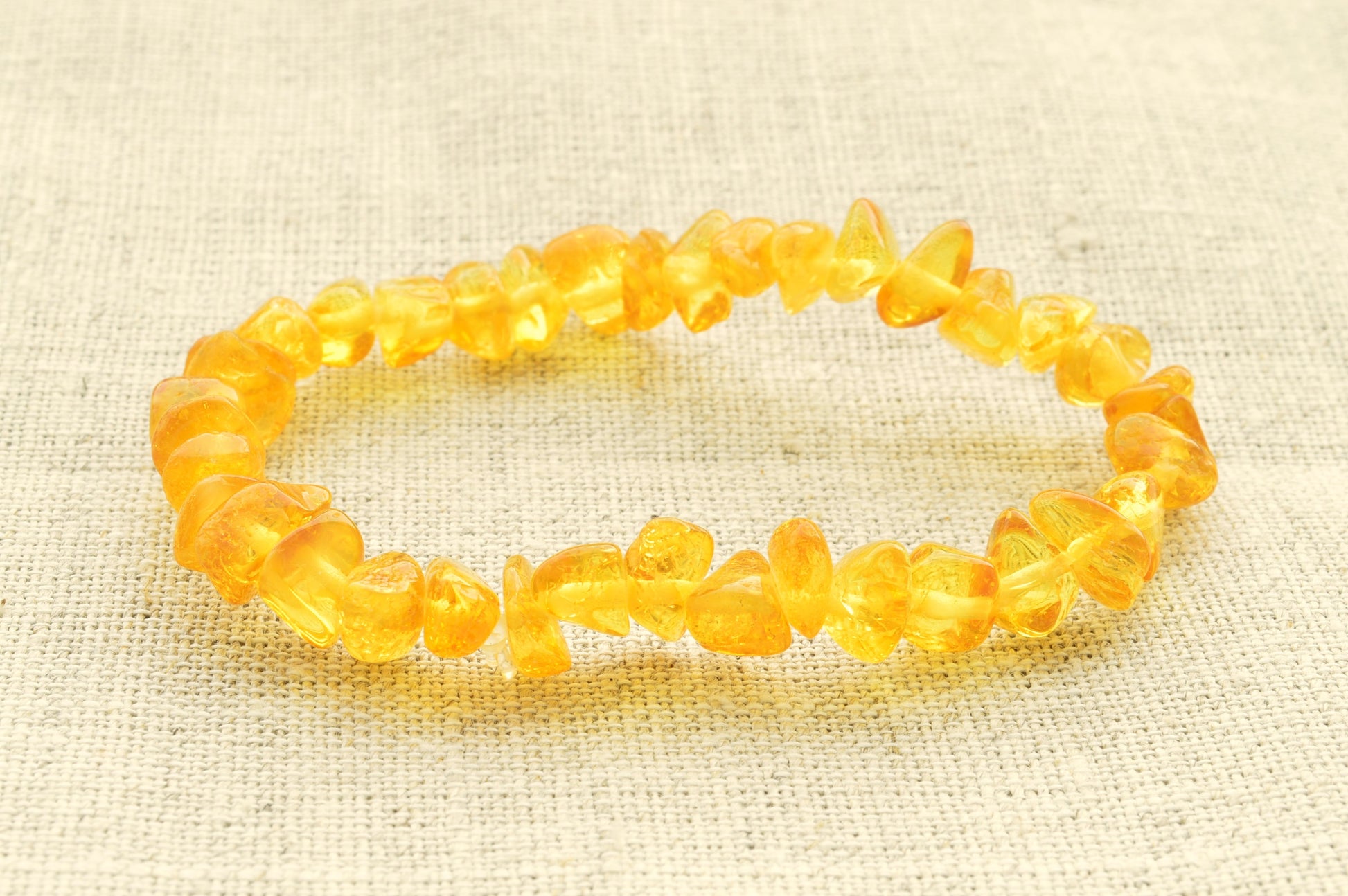 Yellow beaded bracelet on a textured beige background
