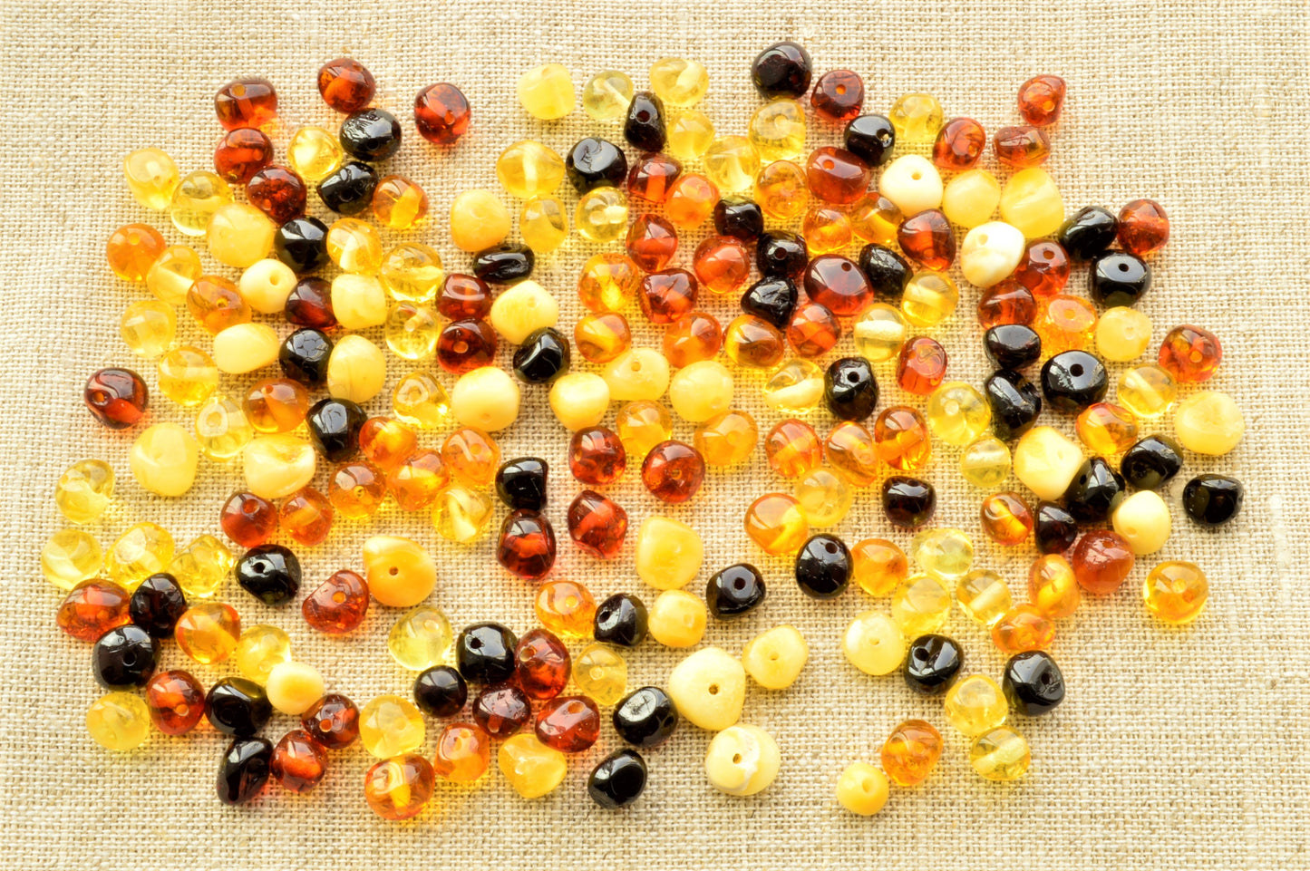 various colors polished amber beads in textured fabric
