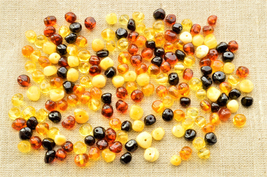various colors polished amber beads in textured fabric