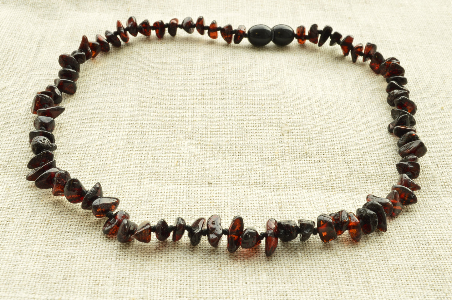 Necklace made of amber beads on a beige fabric background