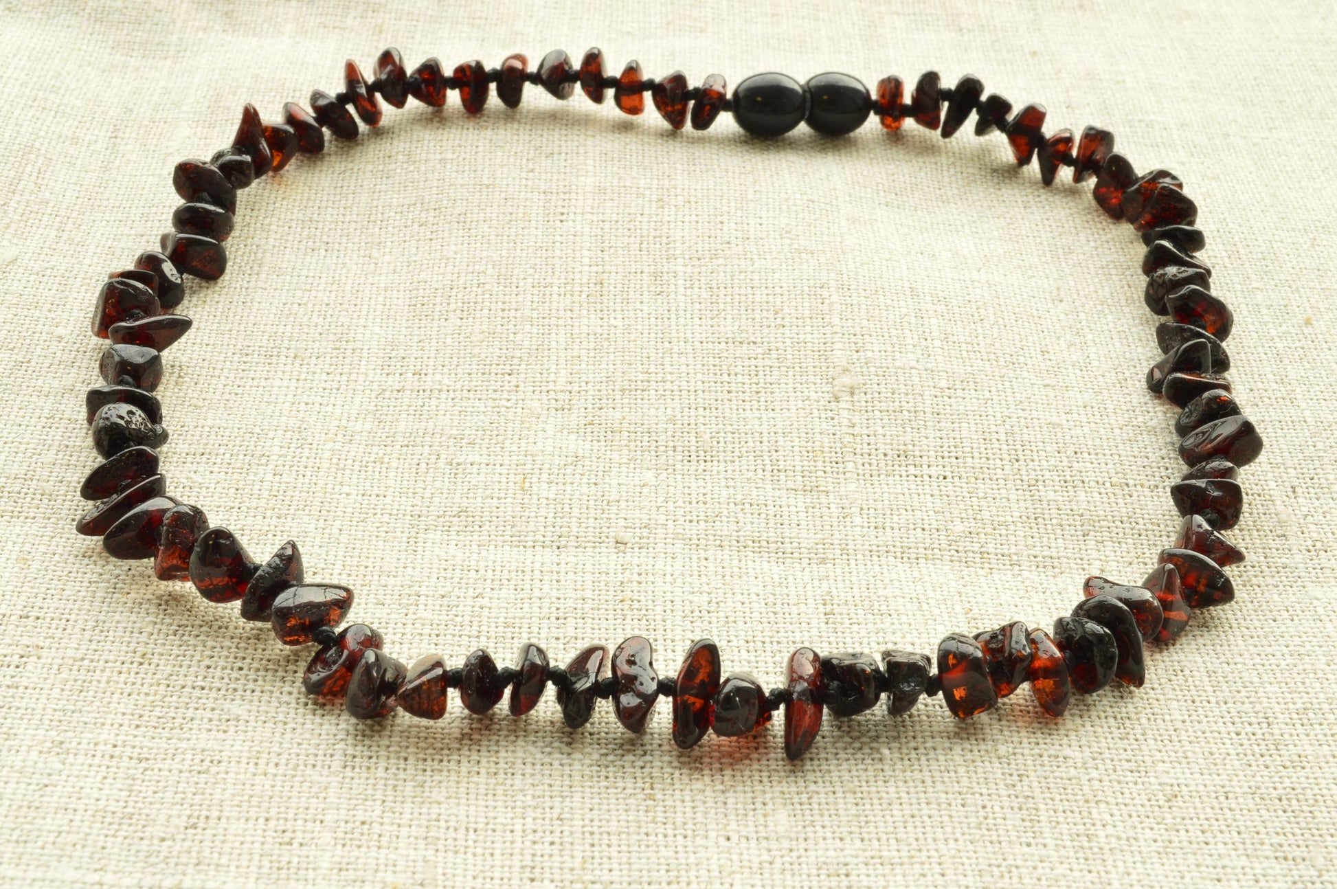 Necklace made of amber beads on a beige fabric background