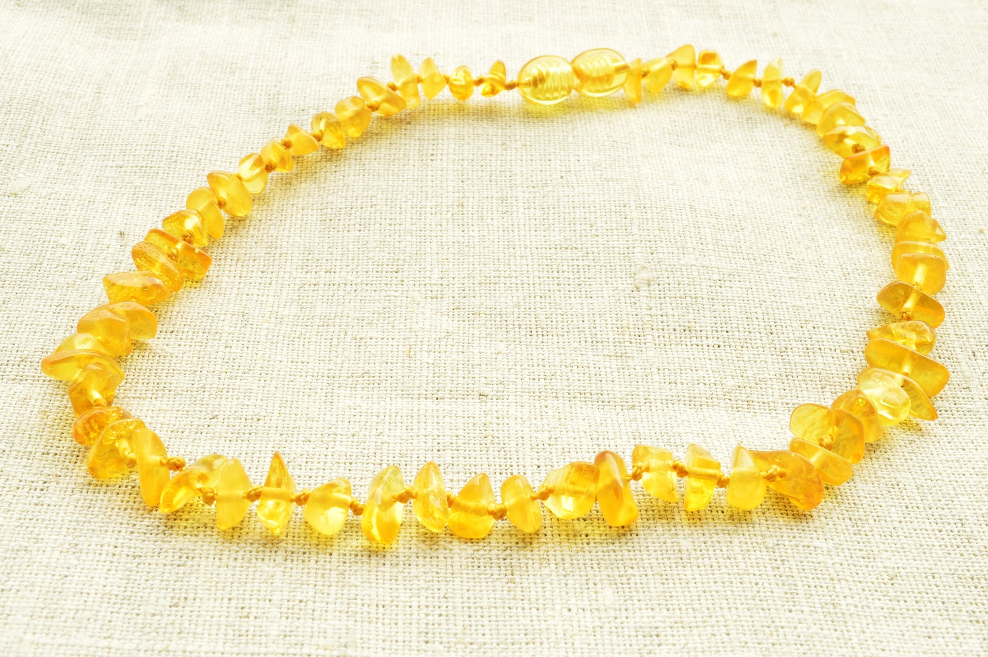 Yellow beaded bracelet on a light fabric background
