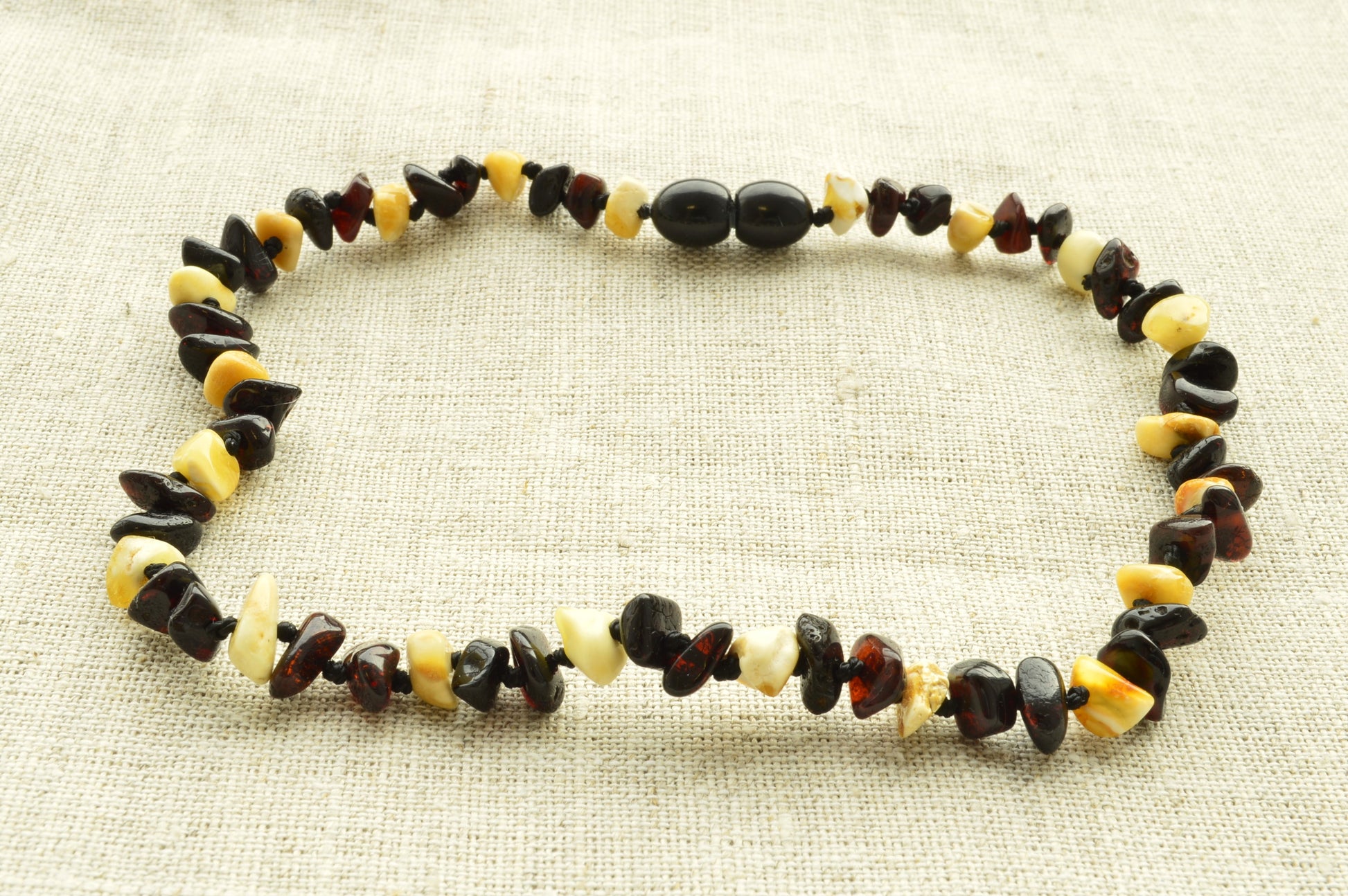 Necklace with multicolored beads on a textured beige background