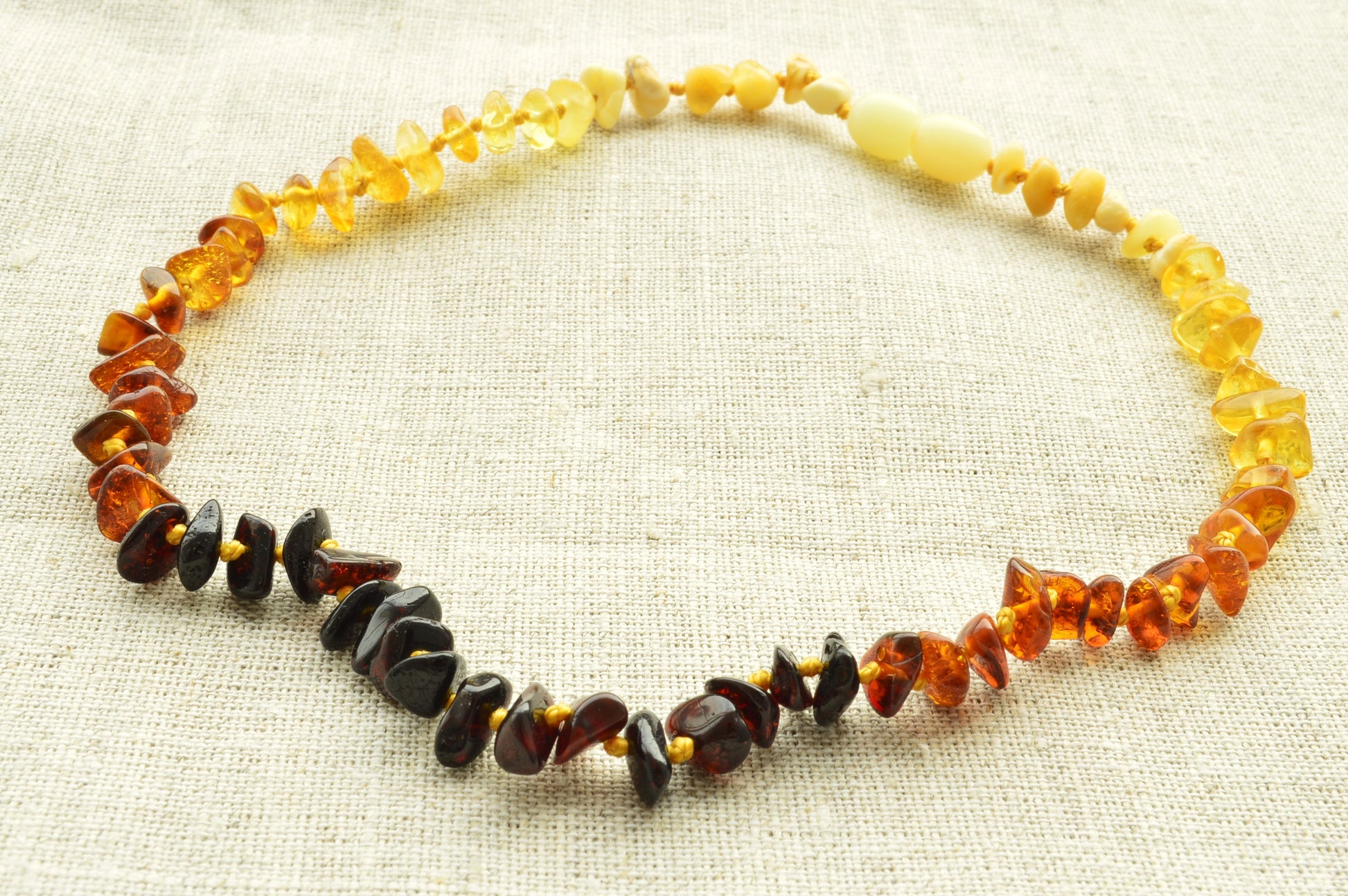 Necklace with multicolored beads on a beige fabric background