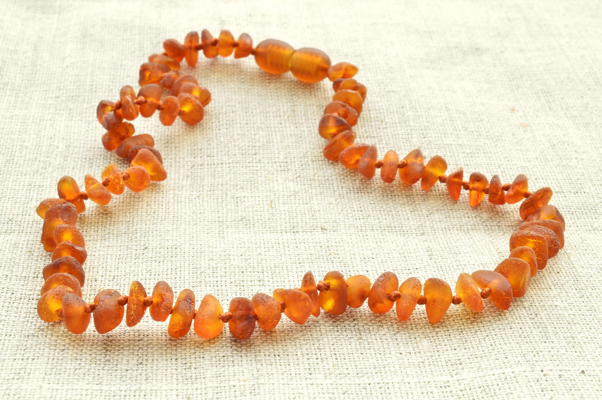 natural baltic amber necklace on a textured fabric background