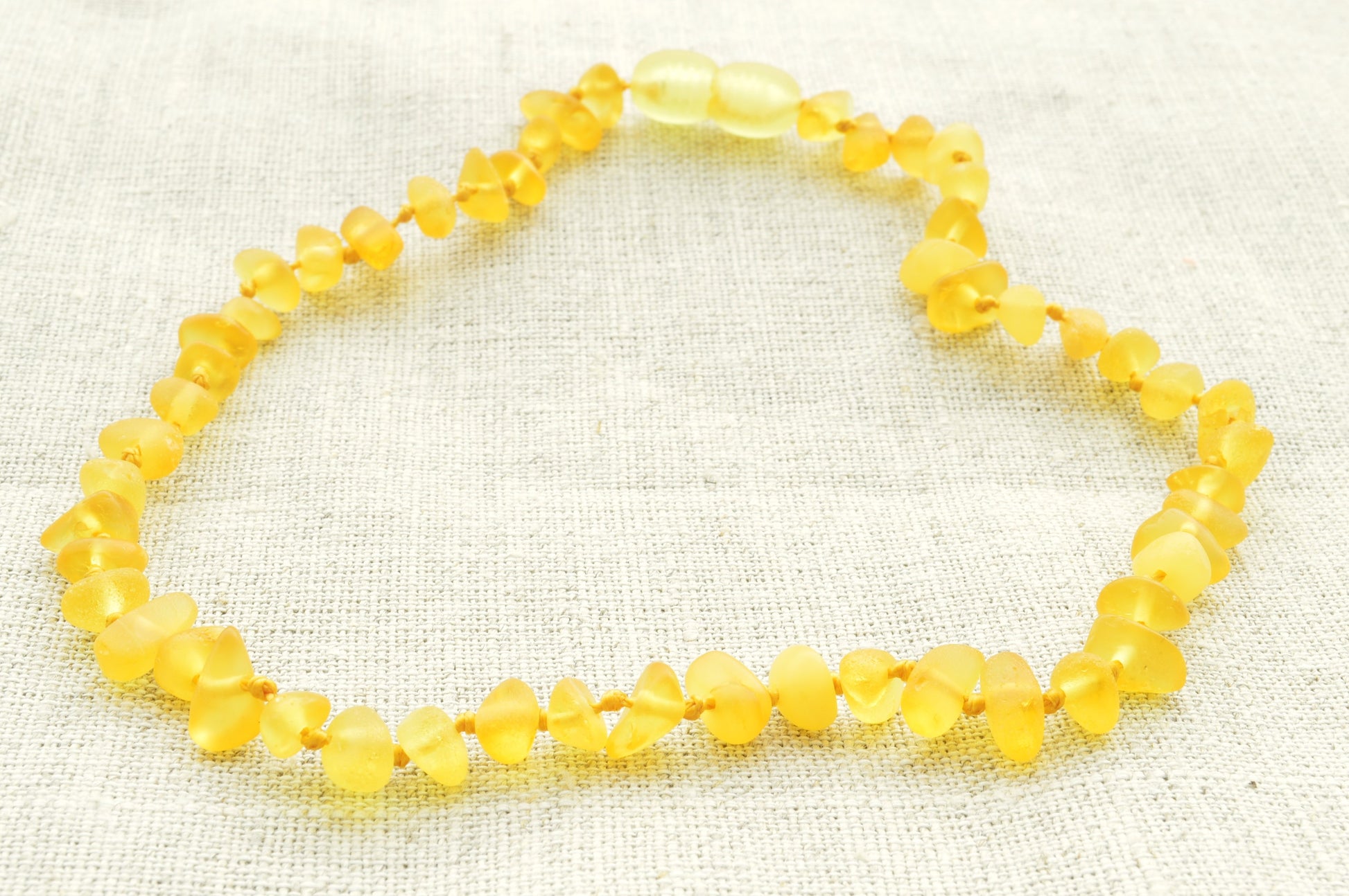 Yellow beaded bracelet on a textured beige background